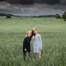 sisters portrait picture taken in green field with storm approaching